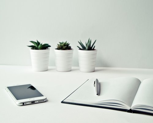 A clean, modern office desk with a notebook and pen