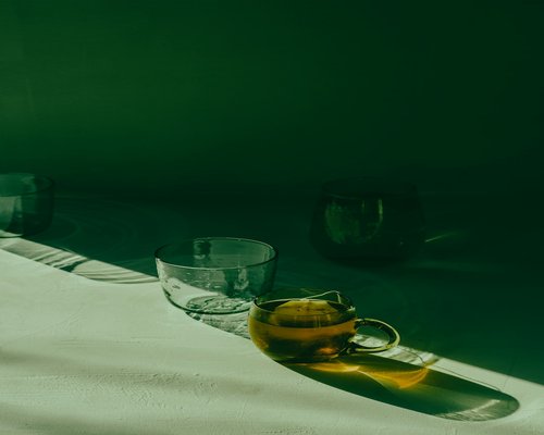 A cup of tea and glasses resting on a table, screens put away