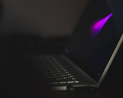 A laptop screen displaying text with soft backlighting in an office